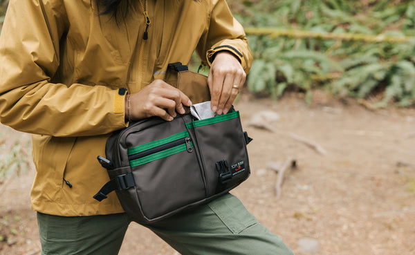 Person pulling an item out of the front buckle pocket of the LGD.